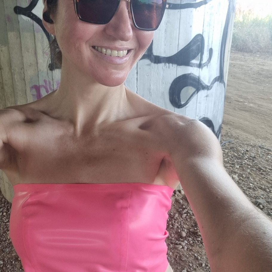 Latexbandeautop Latexbandeautop in pink, sportlich kombiniert mit Sonnenbrille und Cap.